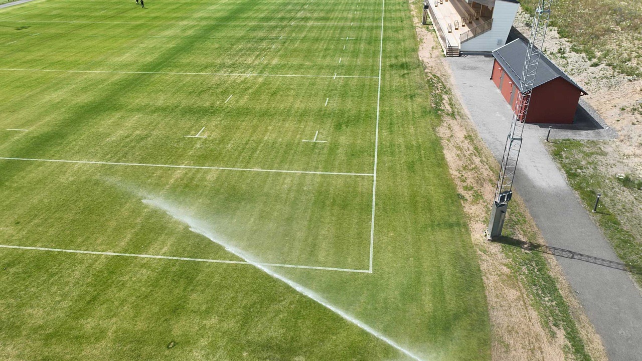 flygfoto av gräsmatta med vattenspridare