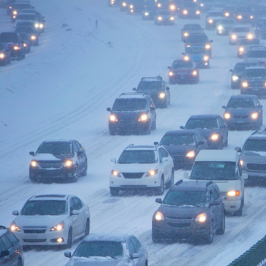 Bild på trafikerad väg i snöoväder.